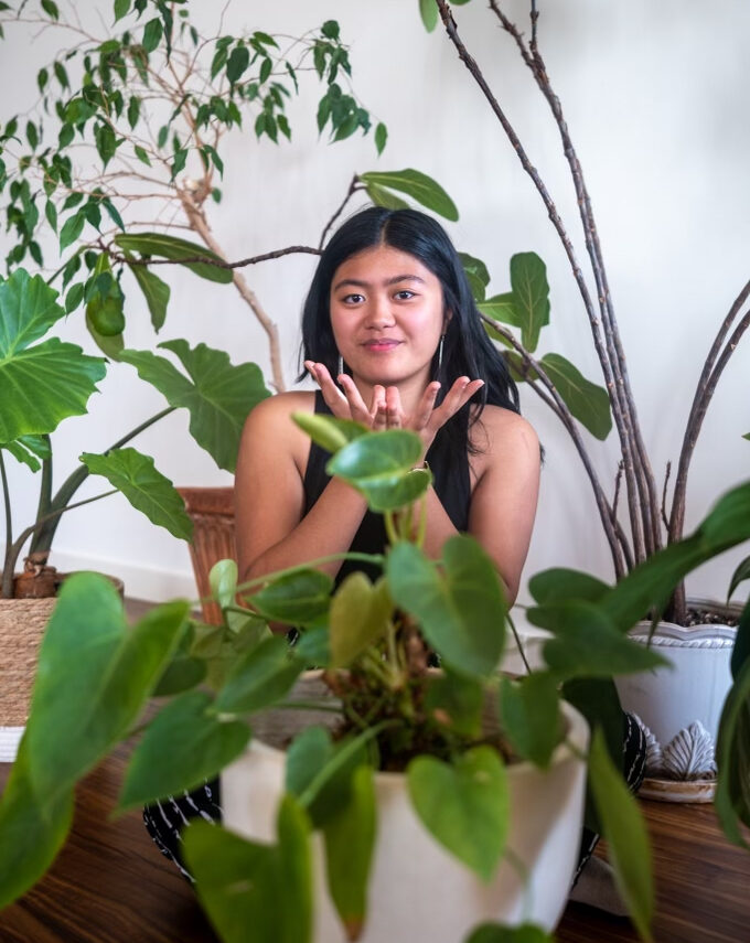 Jaydalen Blossom posing surrounded by house plants